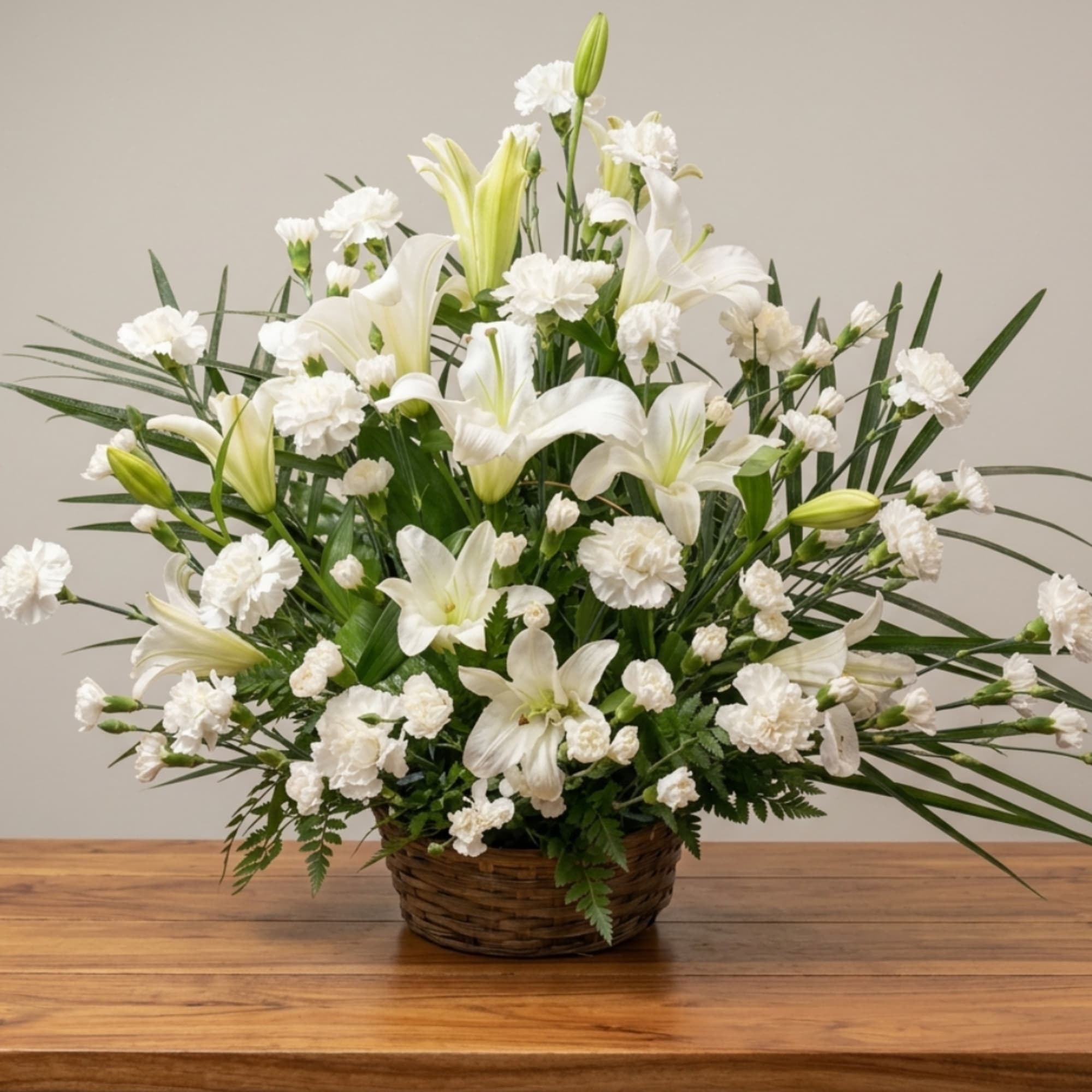 White lilies and carnations arranged in a wicker basket, photo 2 of 2