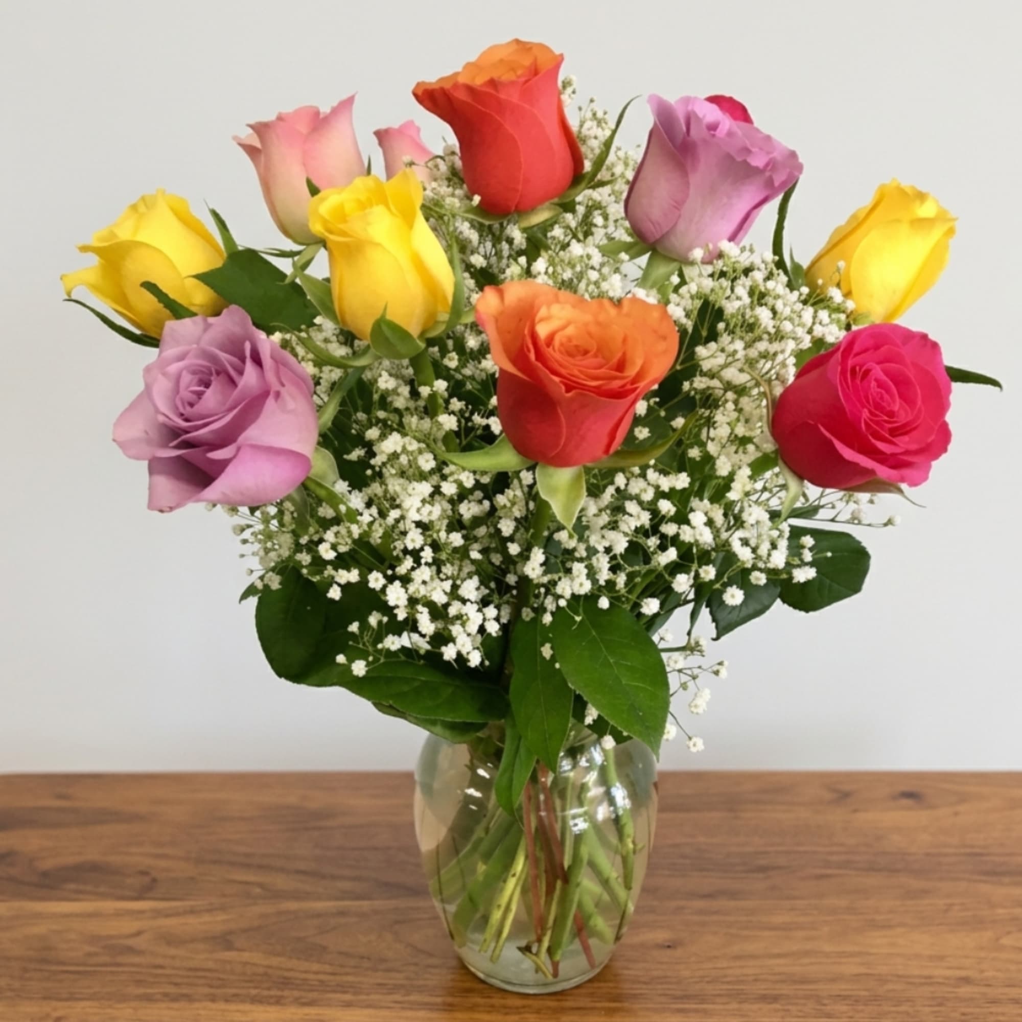 Mixed roses in a clear glass vase with baby's breath