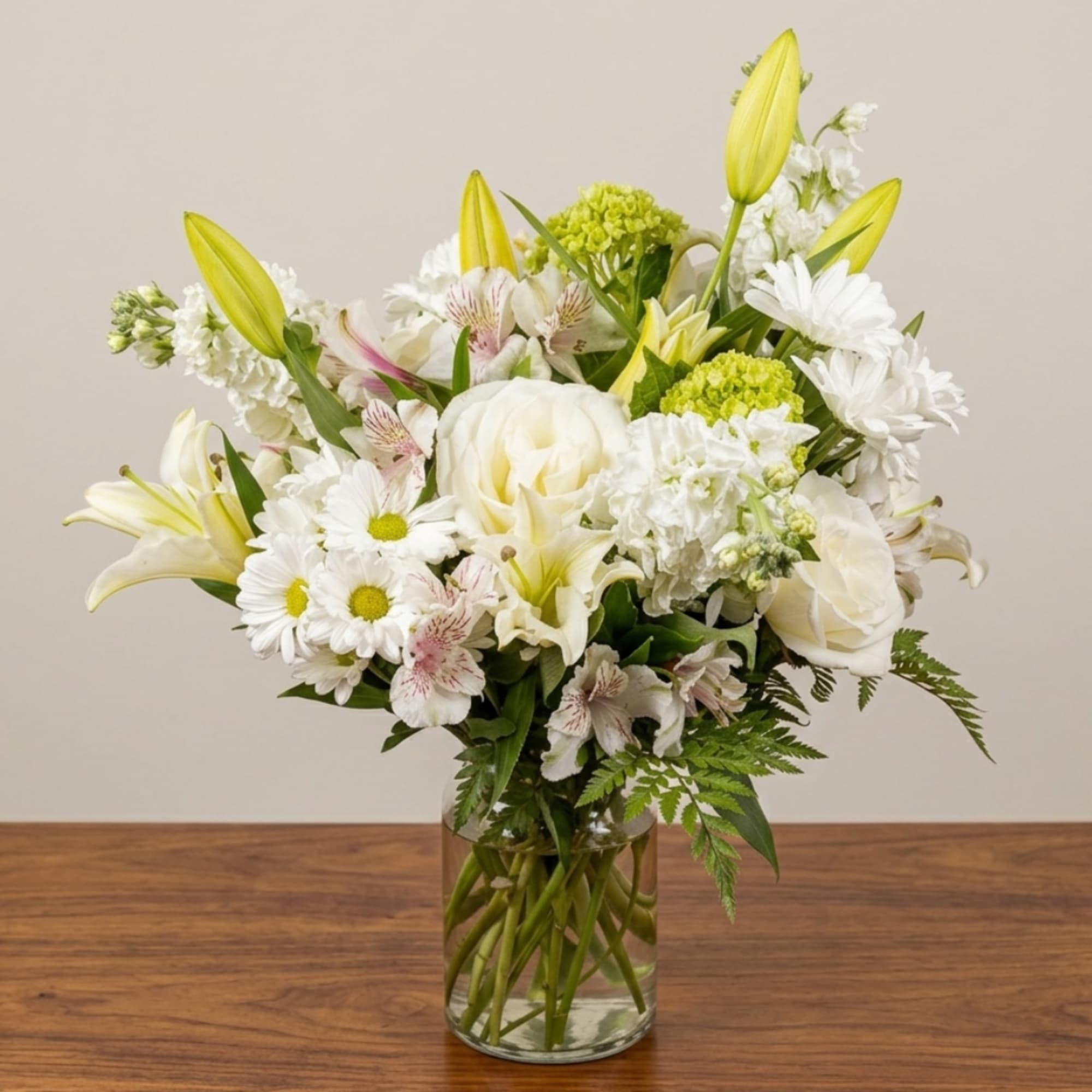 White and yellow bouquet in a clear glass vase