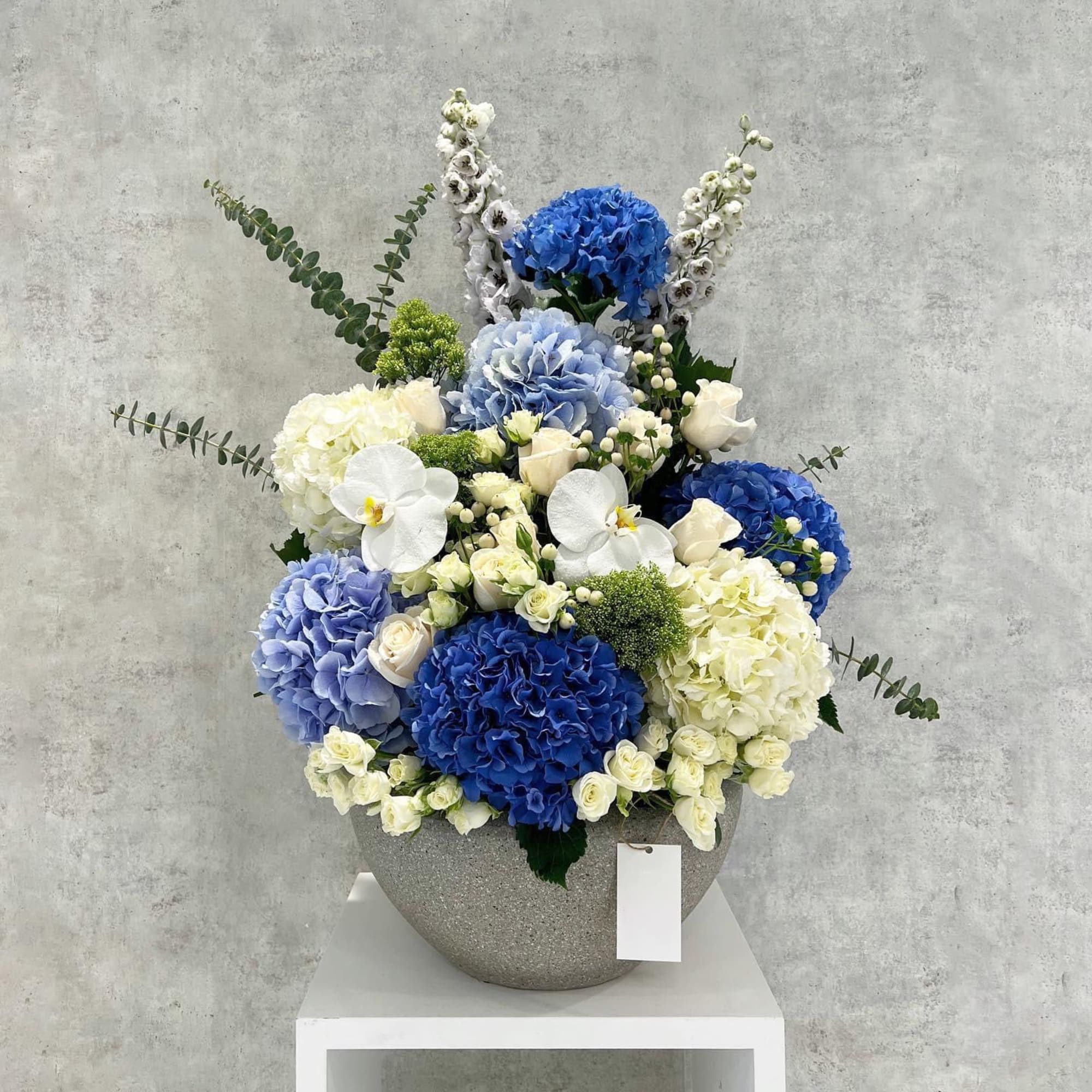 Blue and white floral arrangement in a gray vase