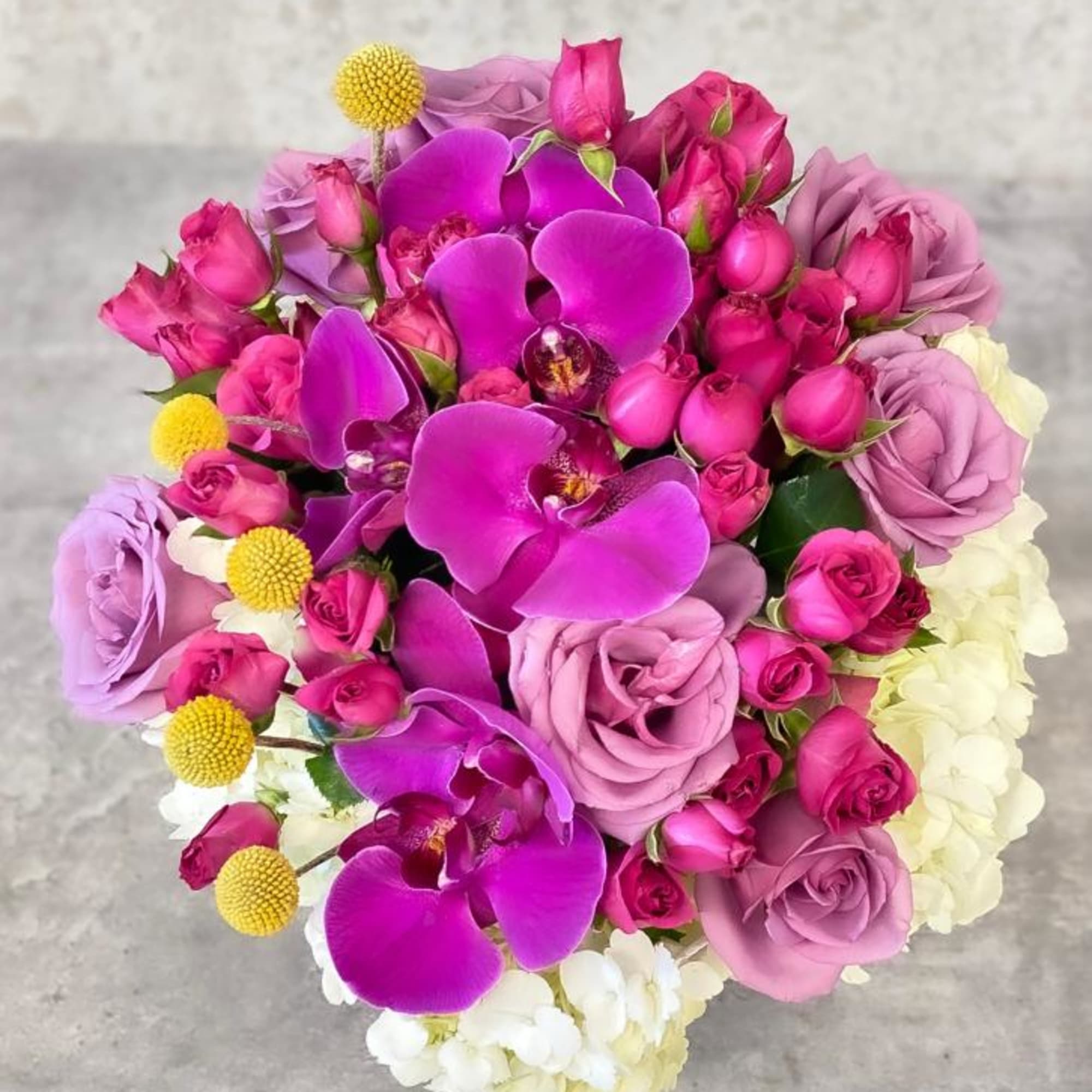 Bouquet of pink roses and purple orchids with white blooms