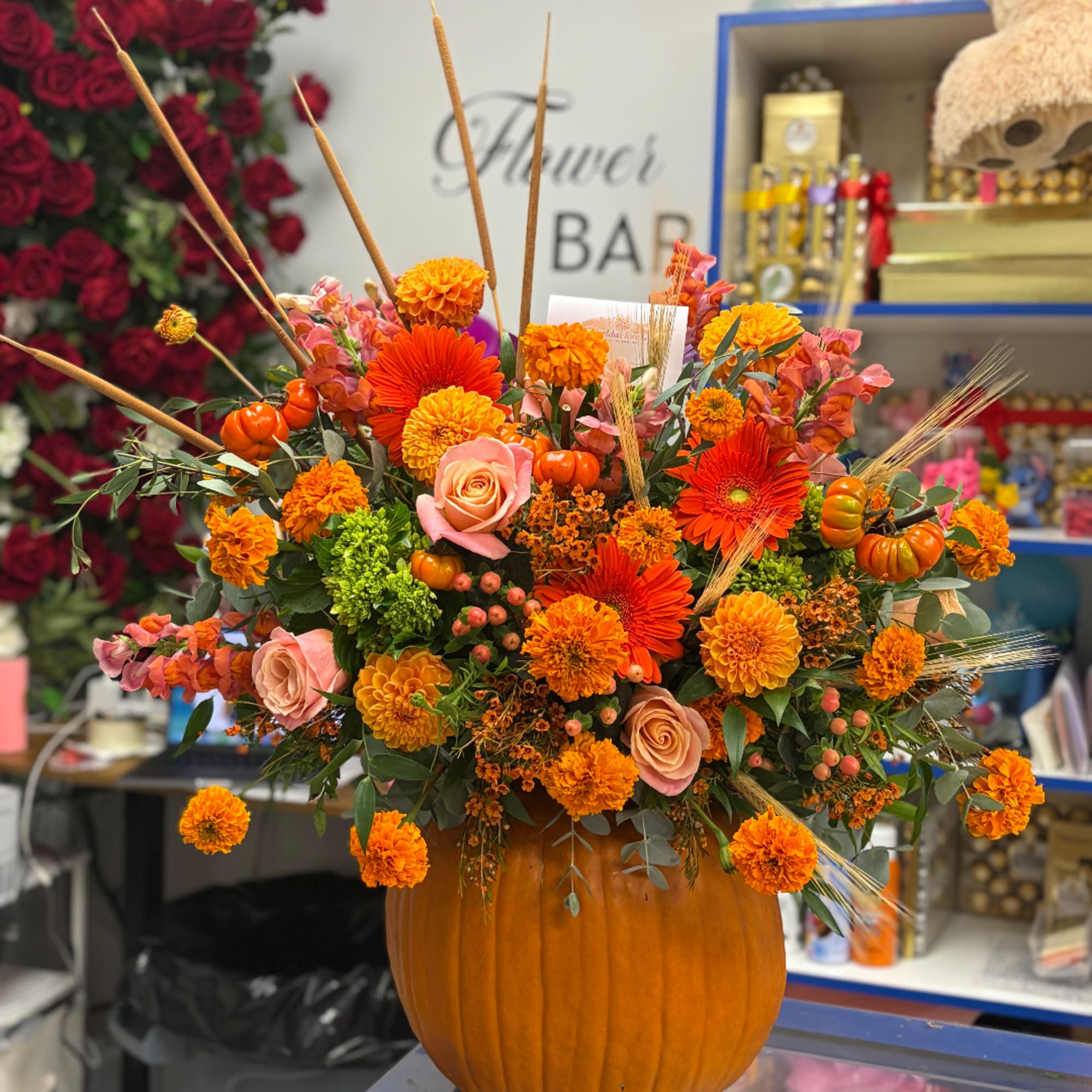 Orange floral arrangement in a pumpkin container with roses and mums, photo 3 of 4