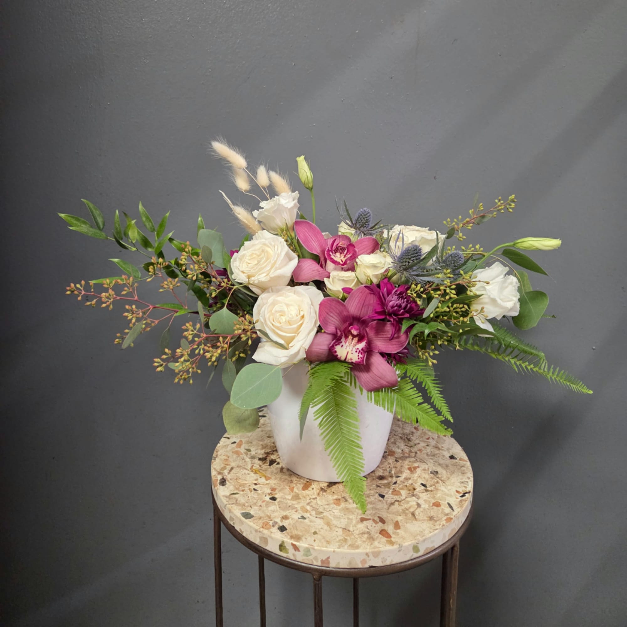 White and magenta floral arrangement in a white vase