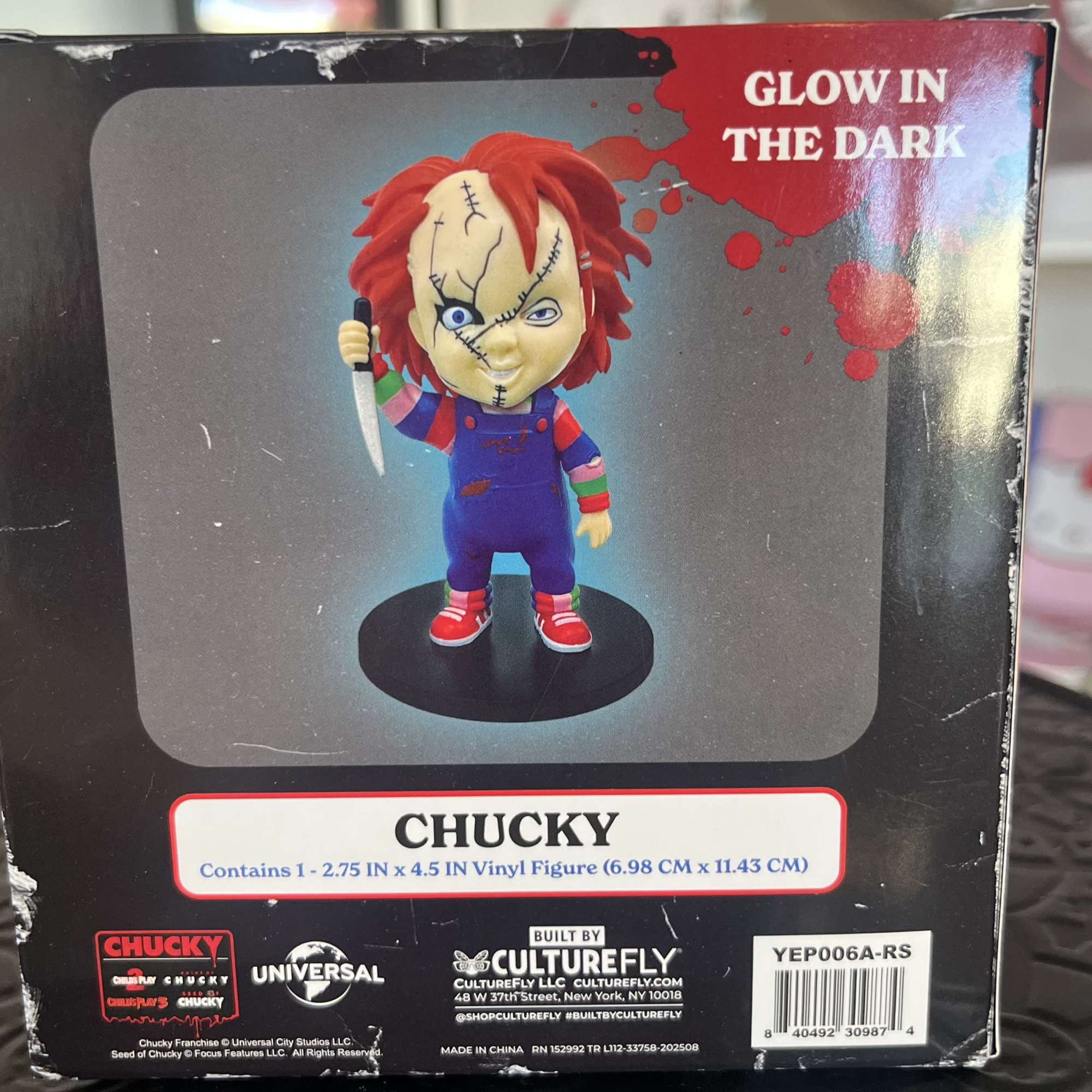 Boxed Chucky vinyl figure with a knife and glow-in-the-dark label