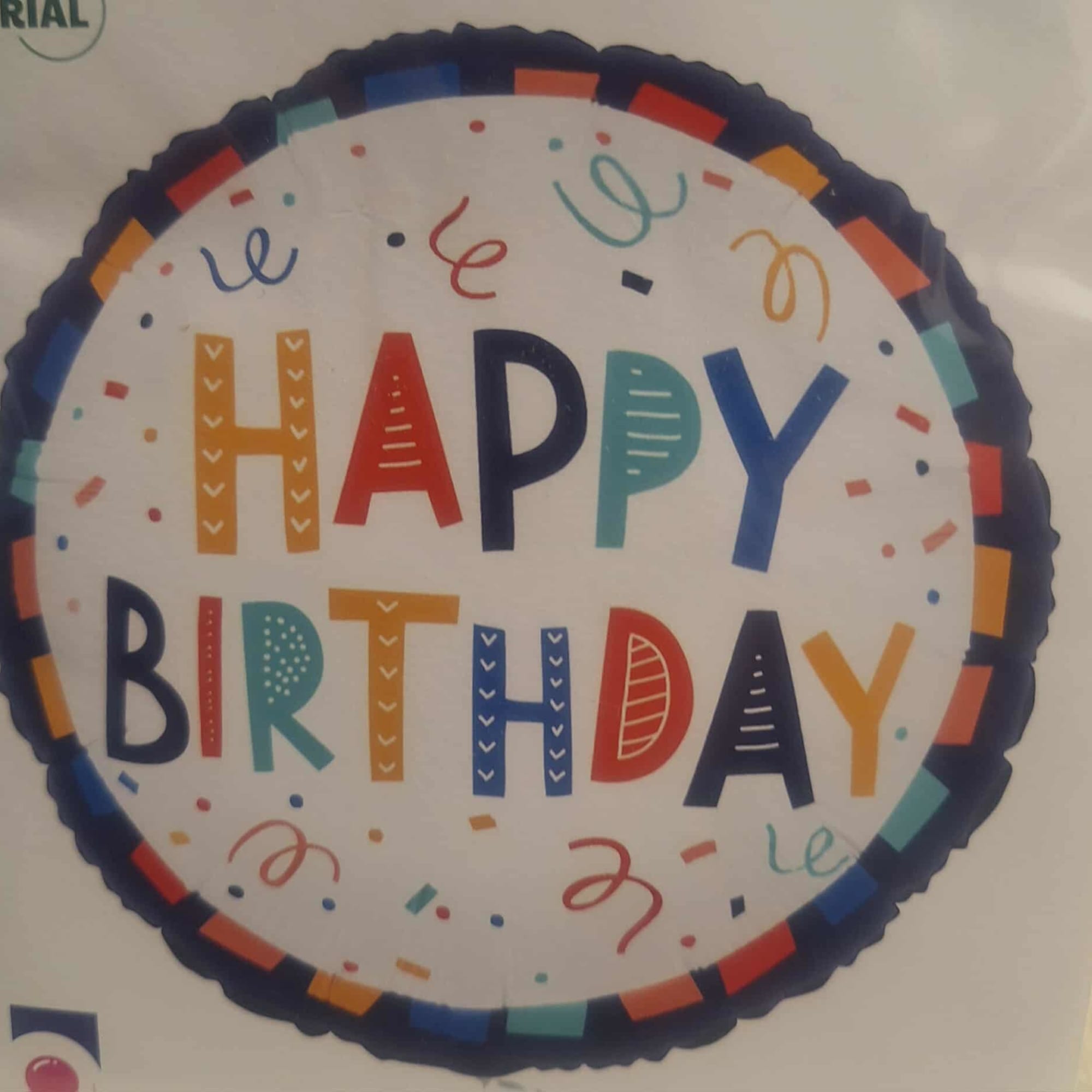 Round foil balloon with colorful Happy Birthday text and confetti accents