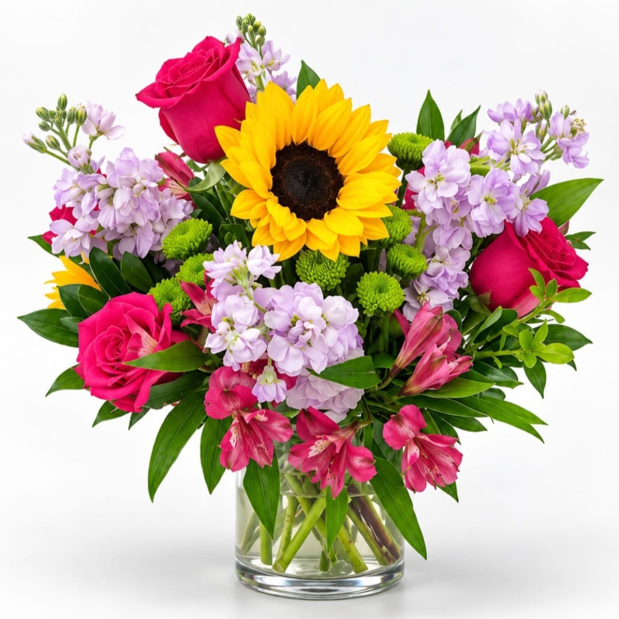 Bouquet of sunflowers, pink roses, and lavender flowers in a glass vase