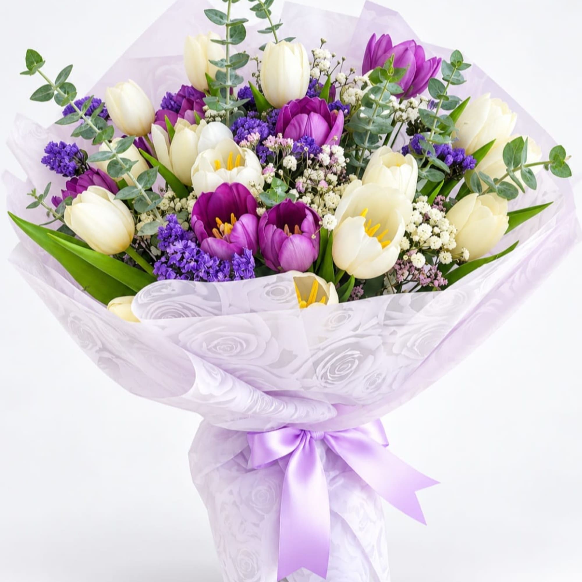 Bouquet of purple and white tulips wrapped in lavender paper