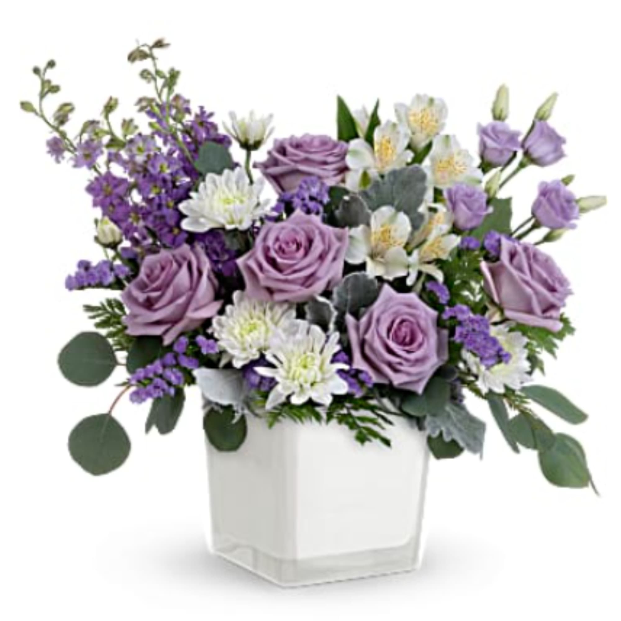 Lavender roses and white flowers in a clear square vase