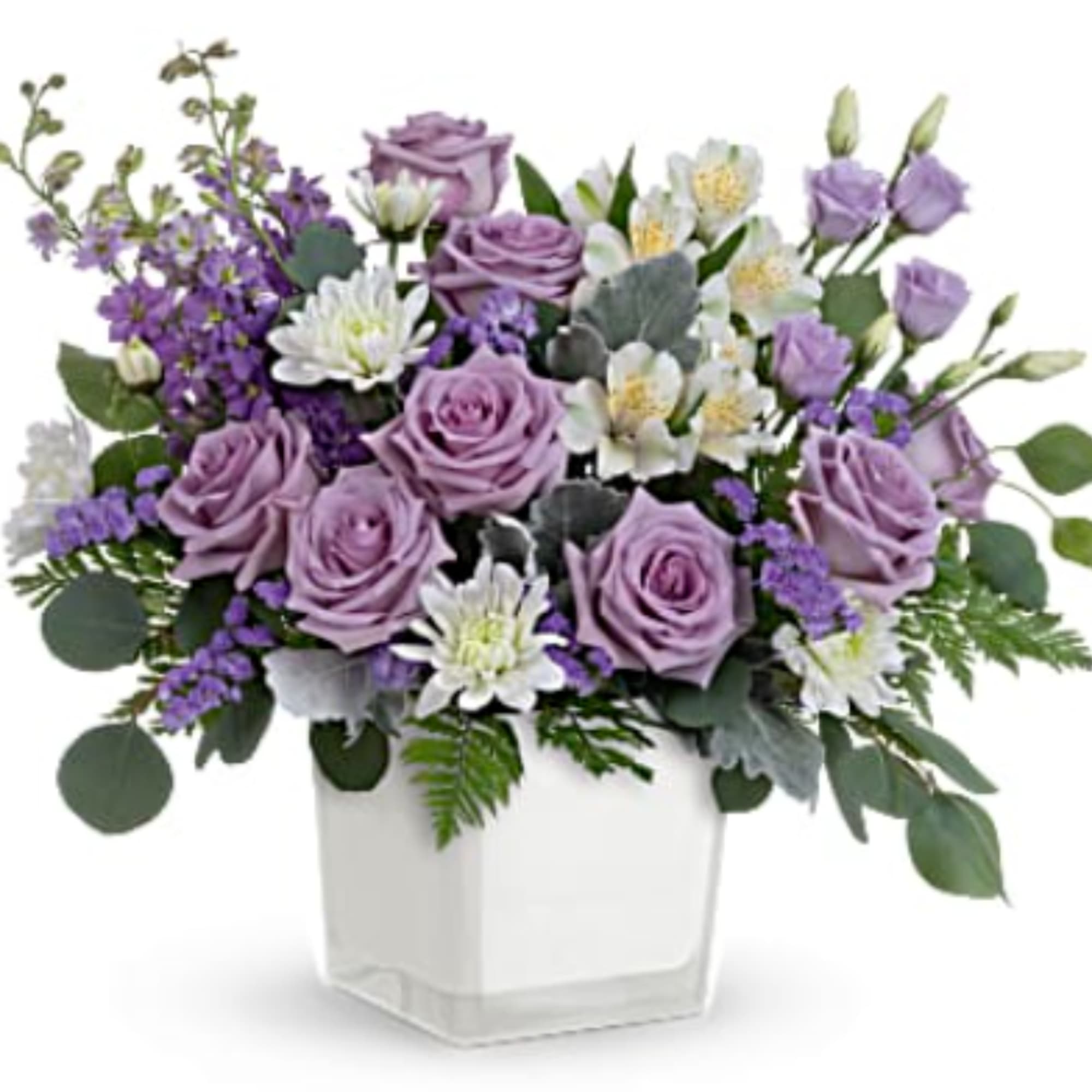 Lavender roses and white flowers arranged in a clear square vase