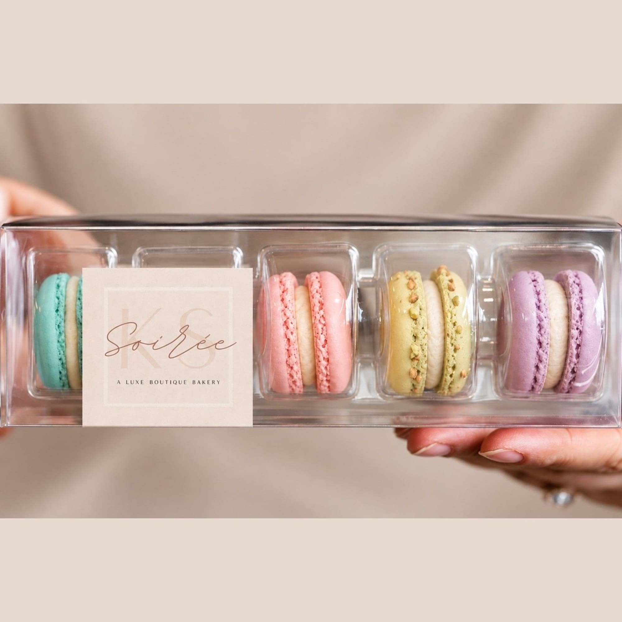 Box of pastel macarons in a clear plastic tray, photo 2 of 2
