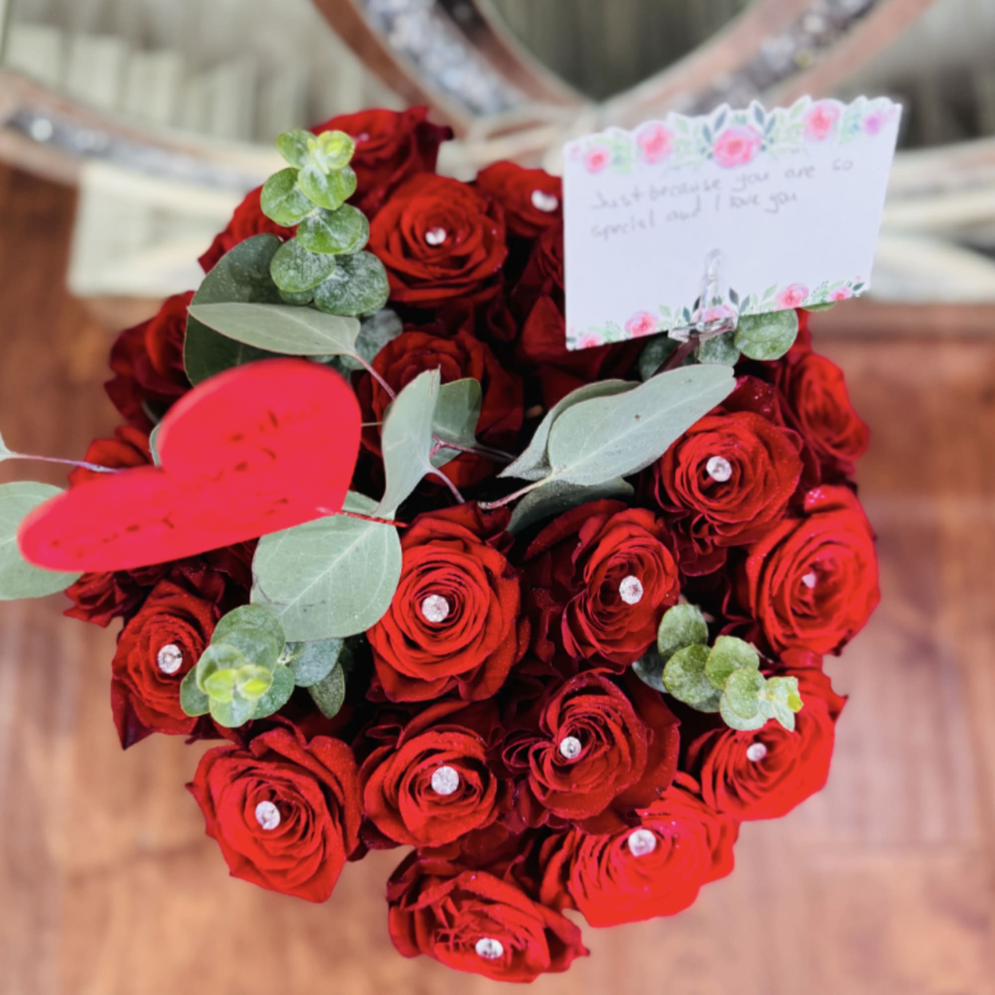 A dense cluster of deep red roses shaped into a lush, heart-forward, photo 2 of 3