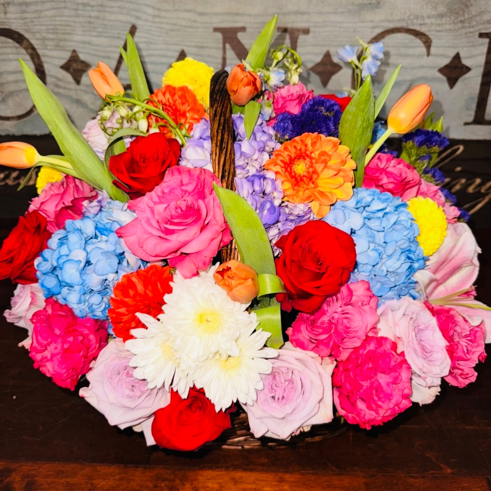Colorful mixed flower basket with roses, hydrangeas, and daisies