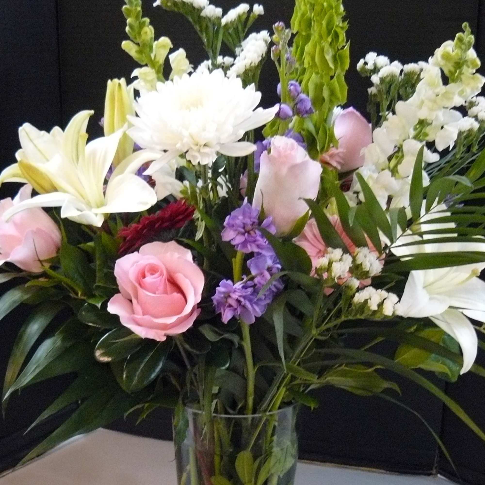Mixed bouquet of pink and white flowers in a clear glass vase