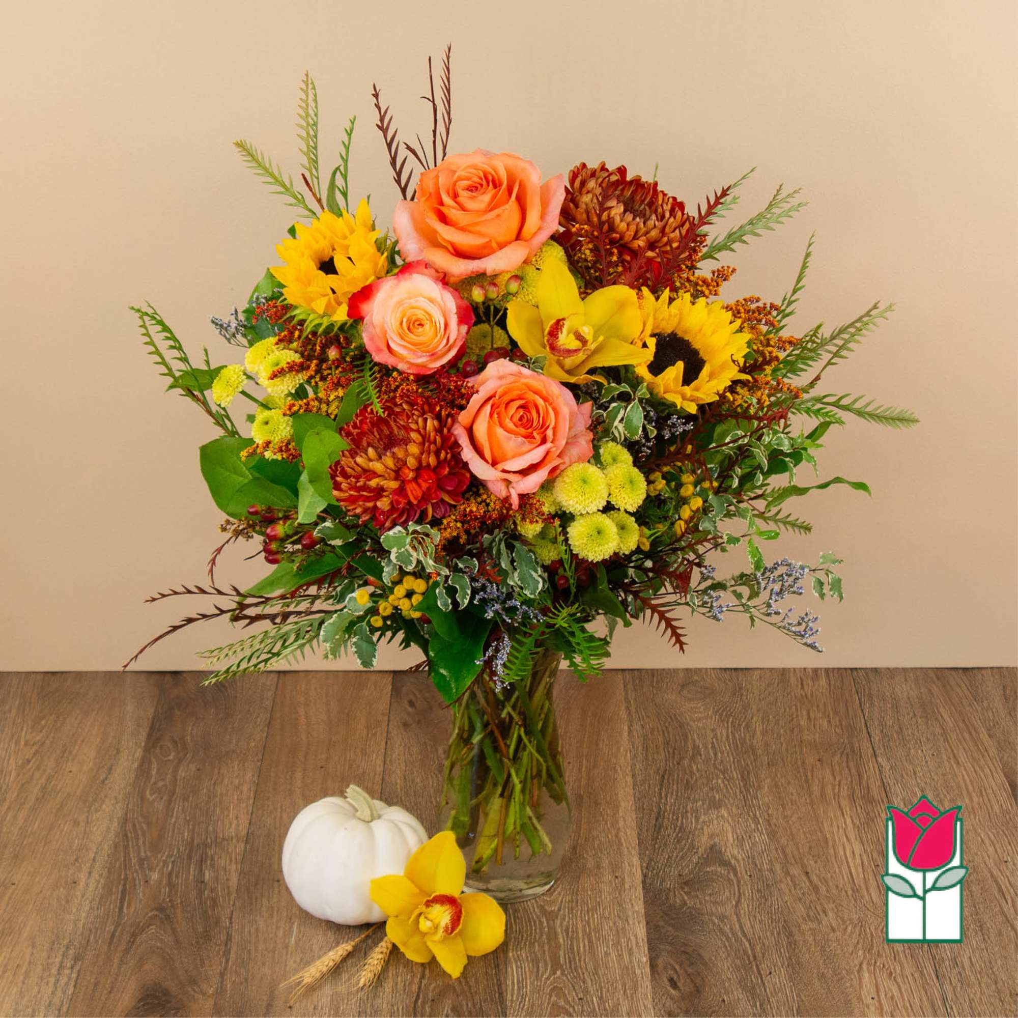 Mixed bouquet in a glass vase with roses, sunflowers, and chrysanthemums