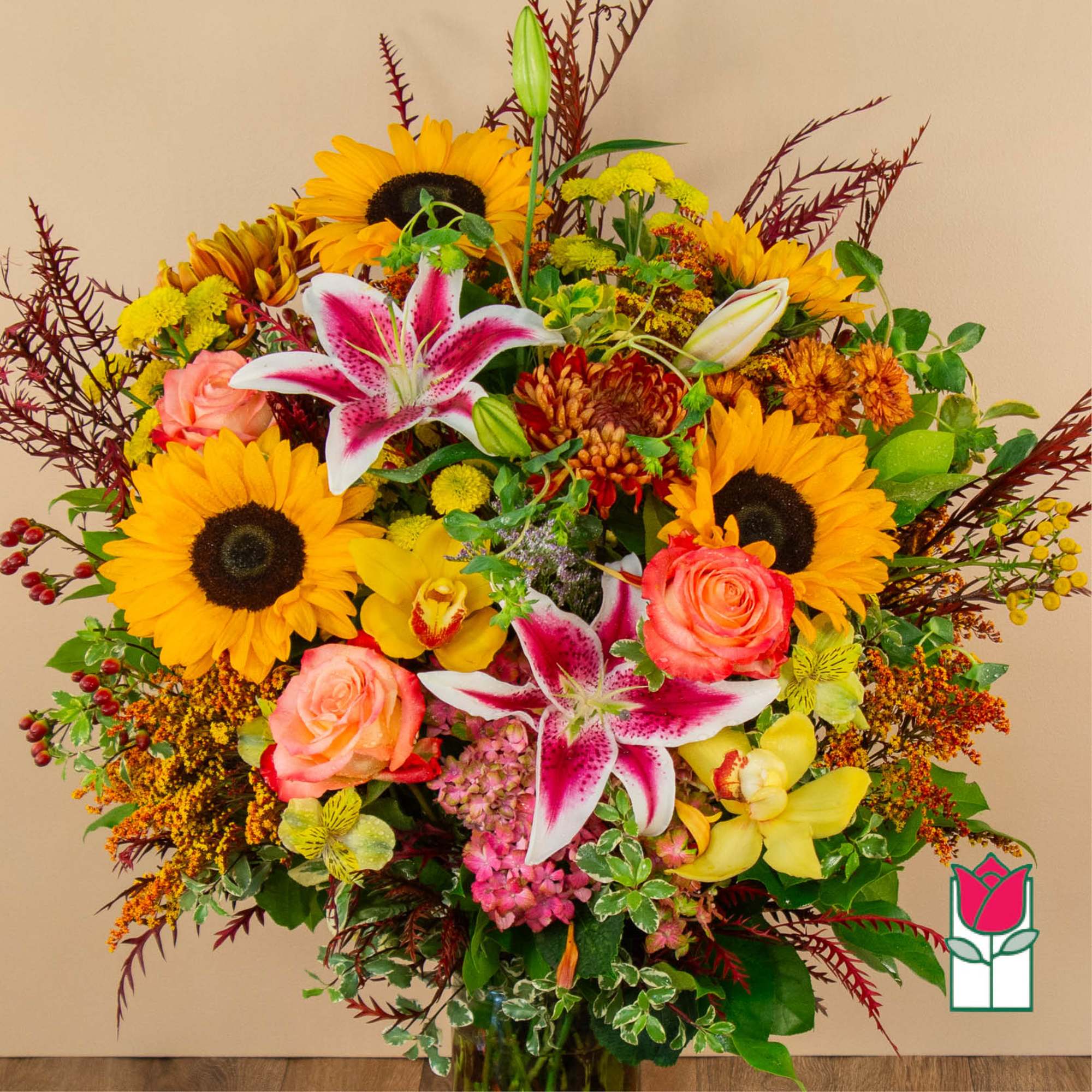 Mixed bouquet with sunflowers, lilies, roses, and orchids in a vase