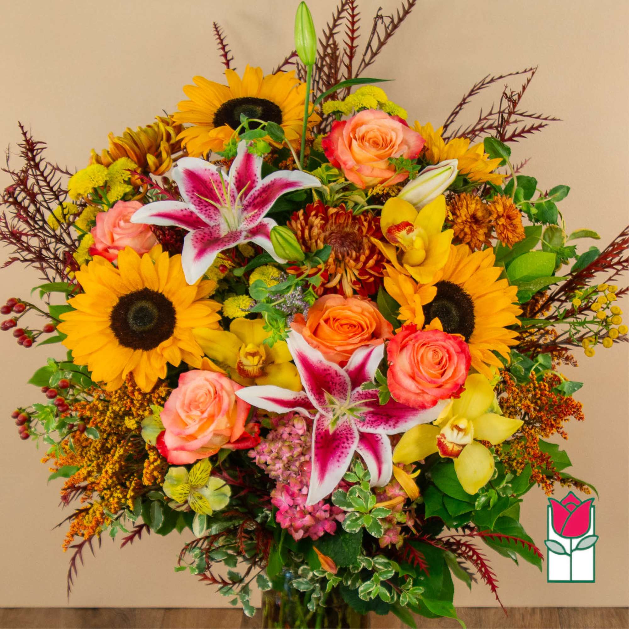Mixed bouquet with sunflowers, roses, lilies, and orchids in a vase