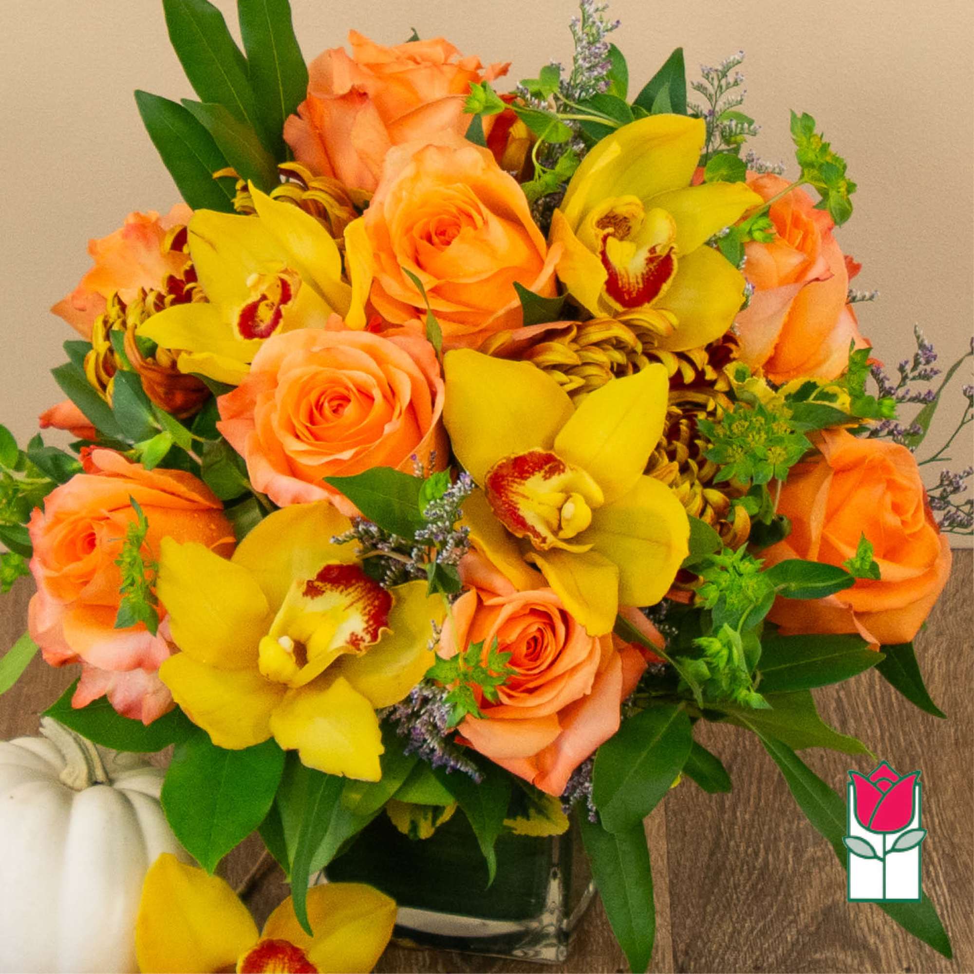 Orange roses and yellow orchids in a glass vase