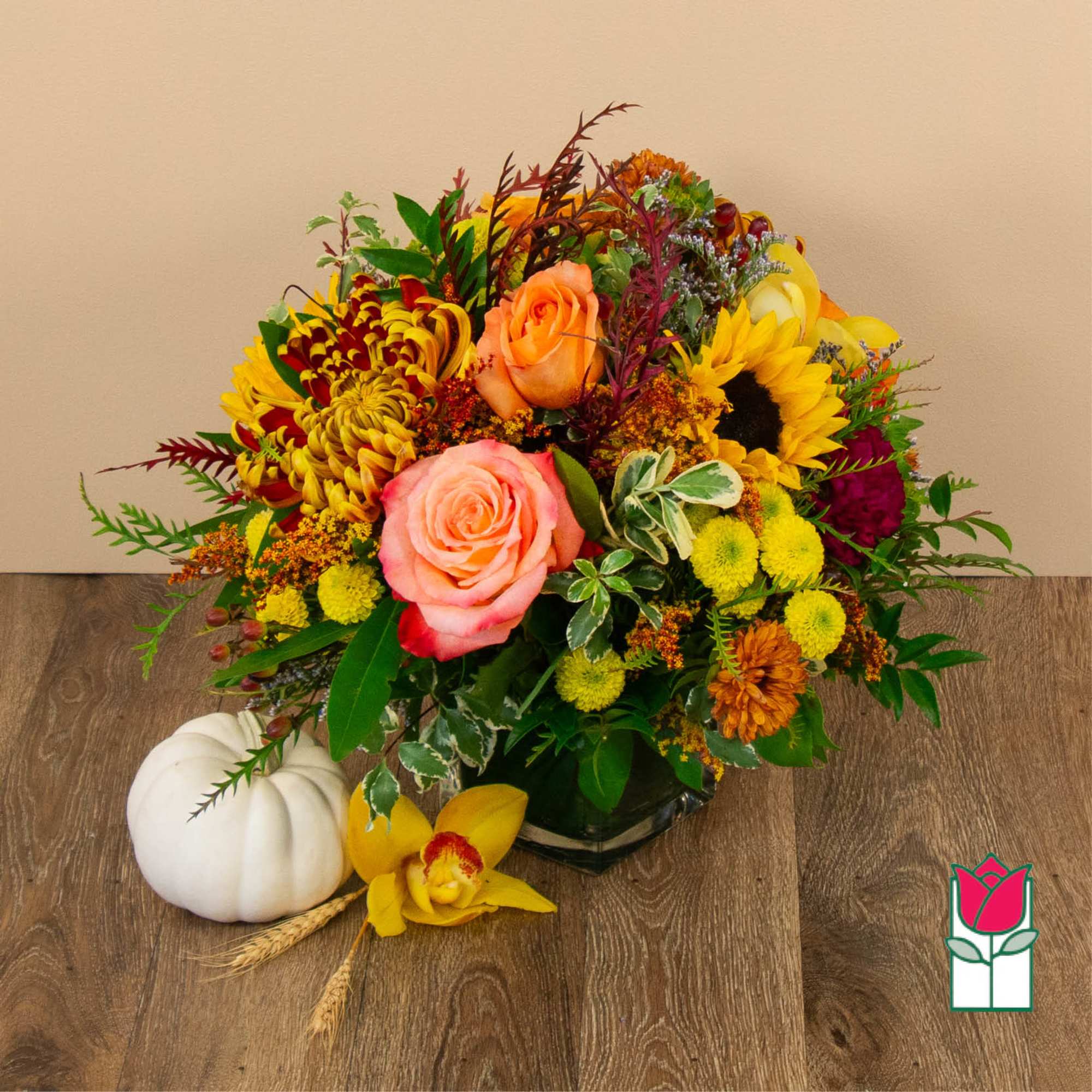 Mixed autumn bouquet with roses, sunflowers, and chrysanthemums in a vase