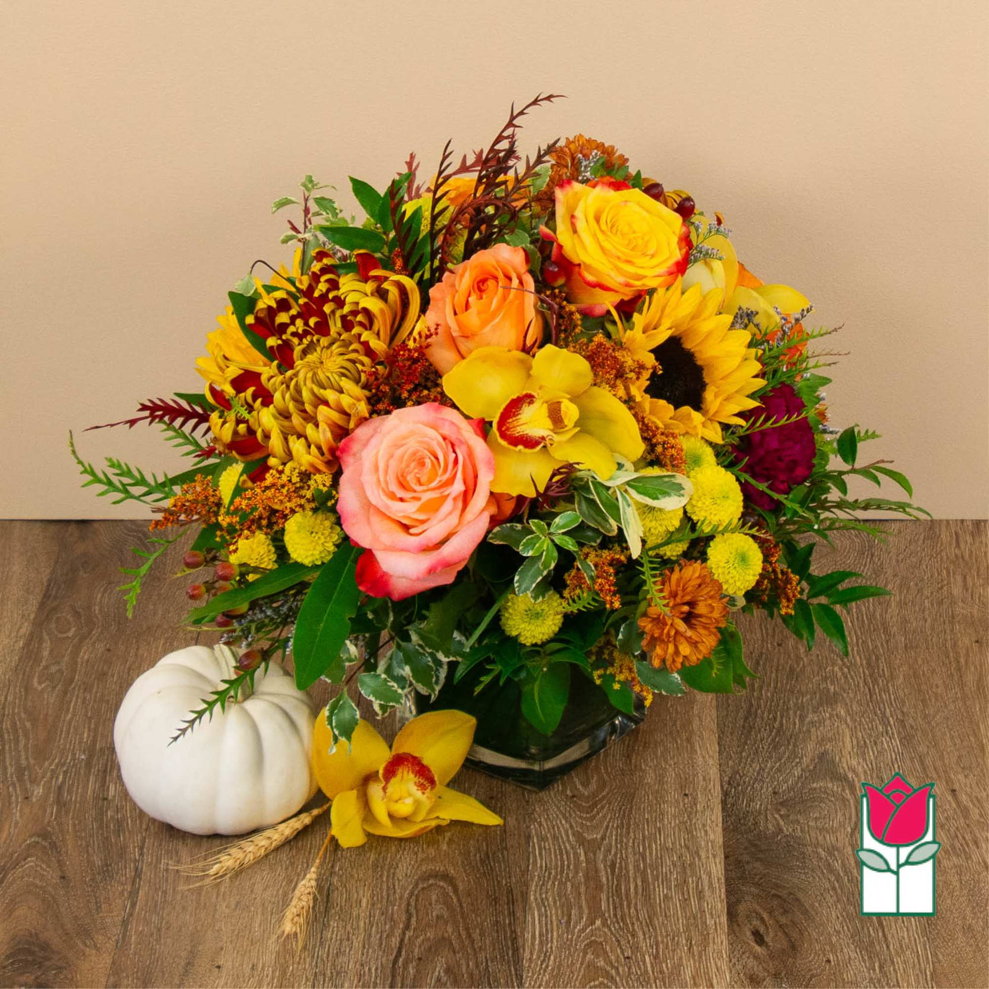Mixed bouquet of roses, sunflowers, and orchids in a low vase