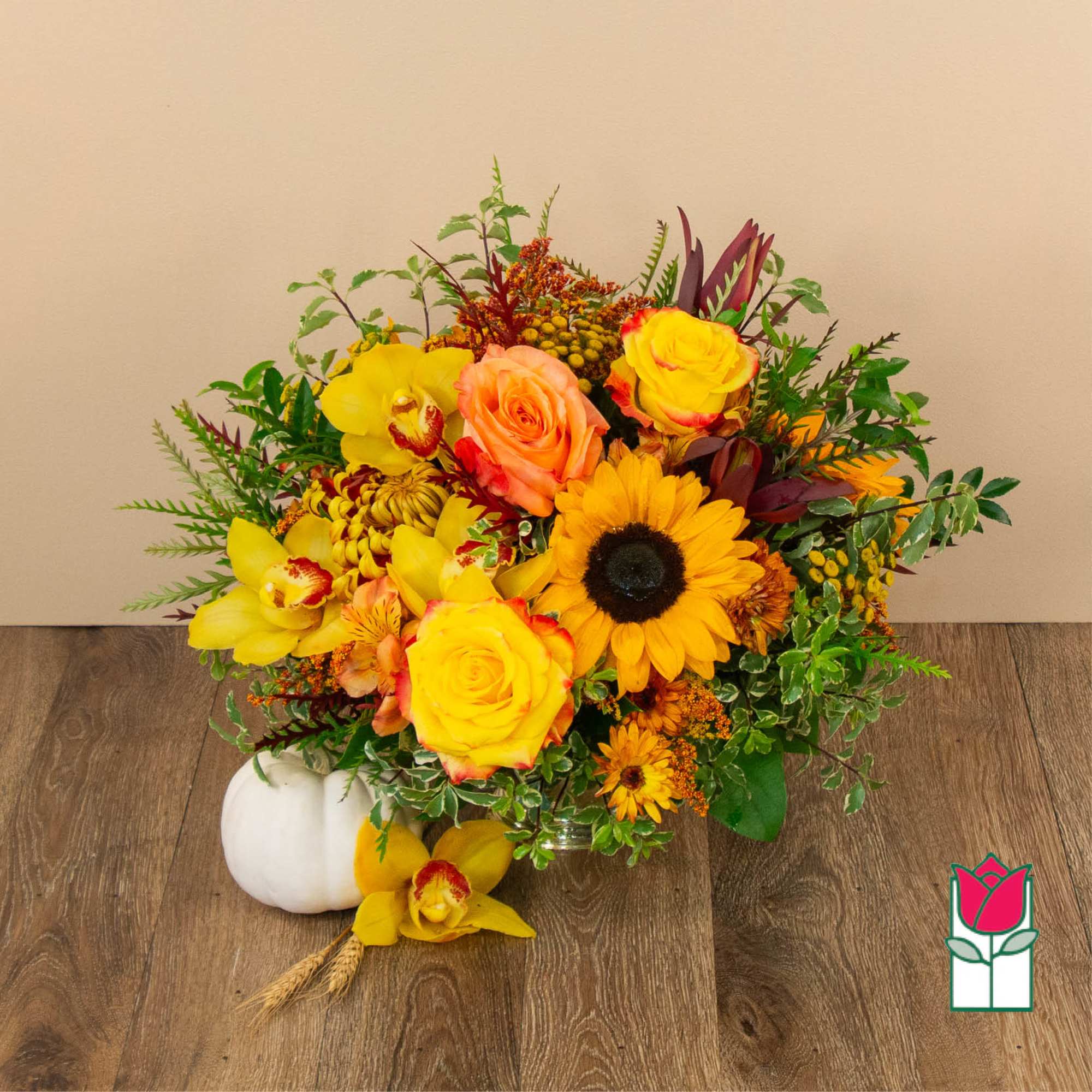 Bright mixed bouquet with yellow sunflowers and roses in a low vase