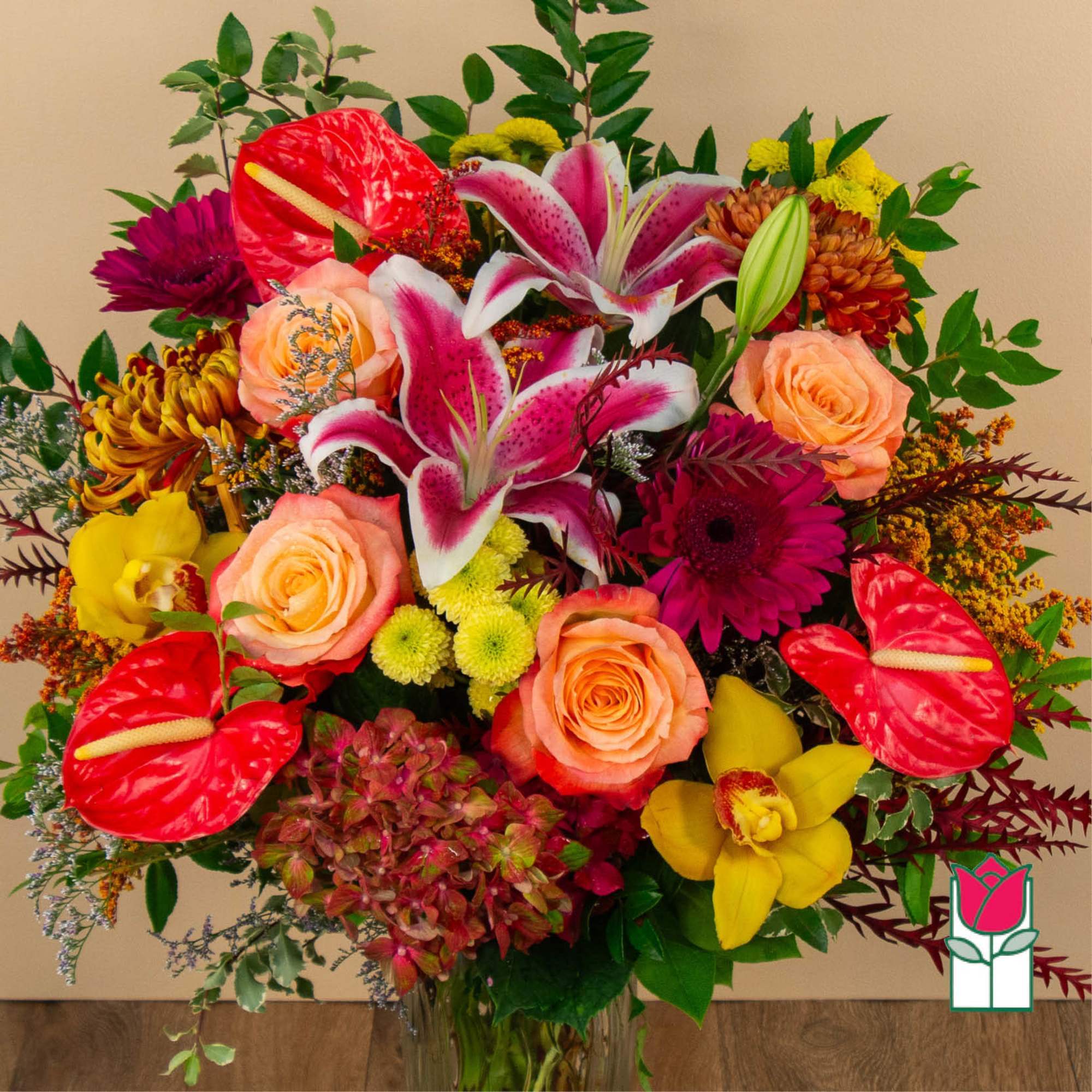 Colorful bouquet with roses, lilies, orchids, and mixed blooms in a glass vase