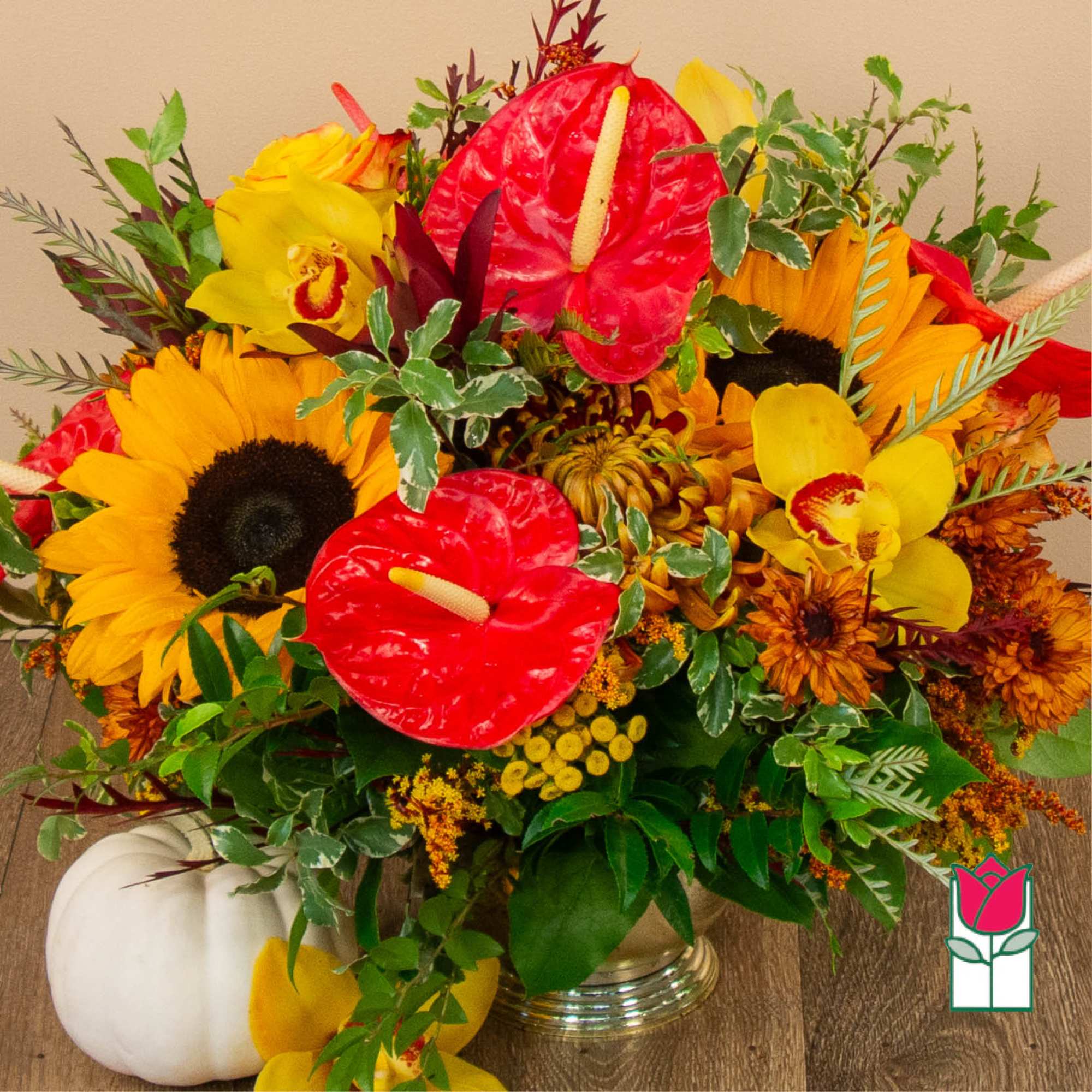 Bright mixed bouquet with sunflowers, red anthuriums, and yellow orchids in a vase
