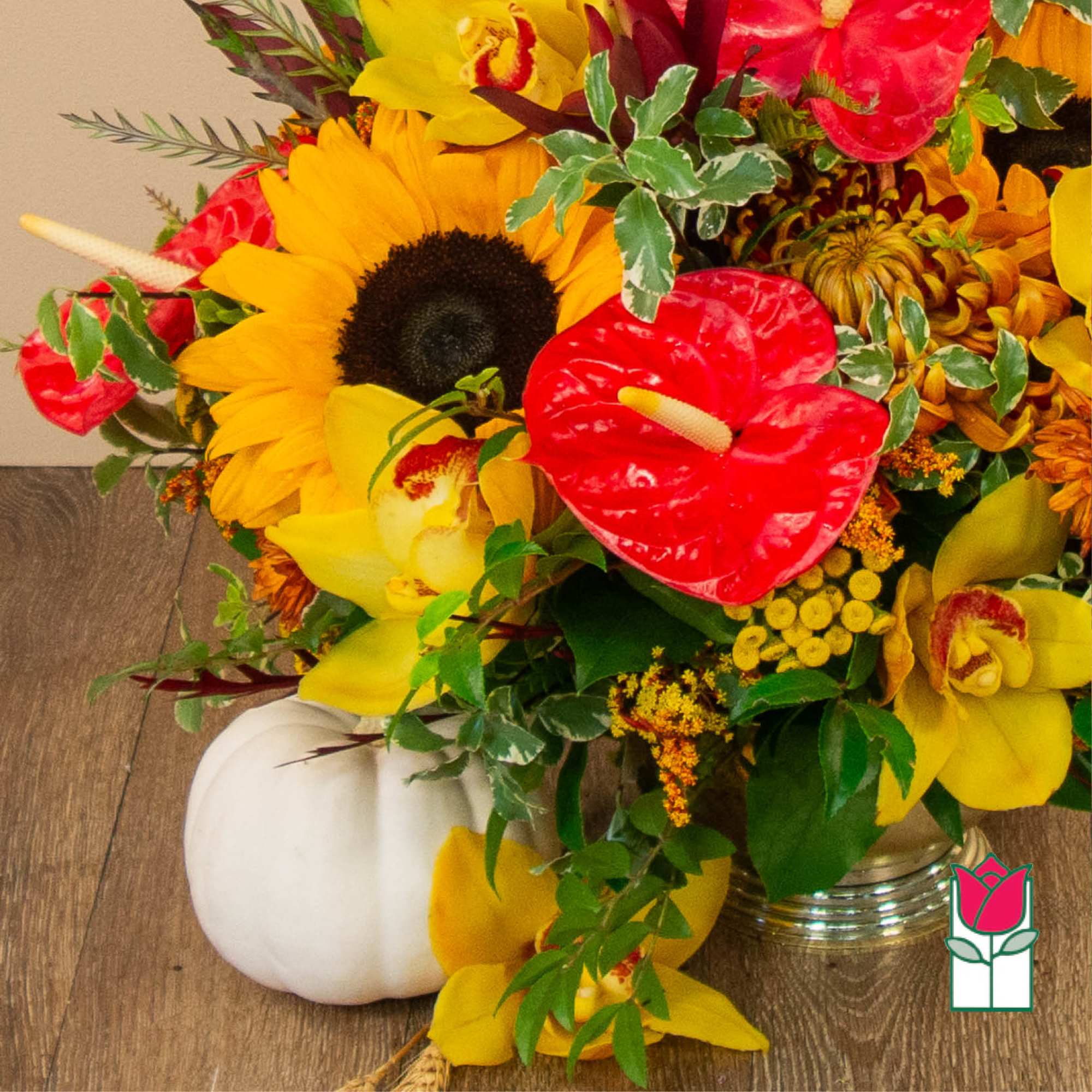 Mixed bouquet with sunflowers, red anthuriums, and yellow orchids in a vase