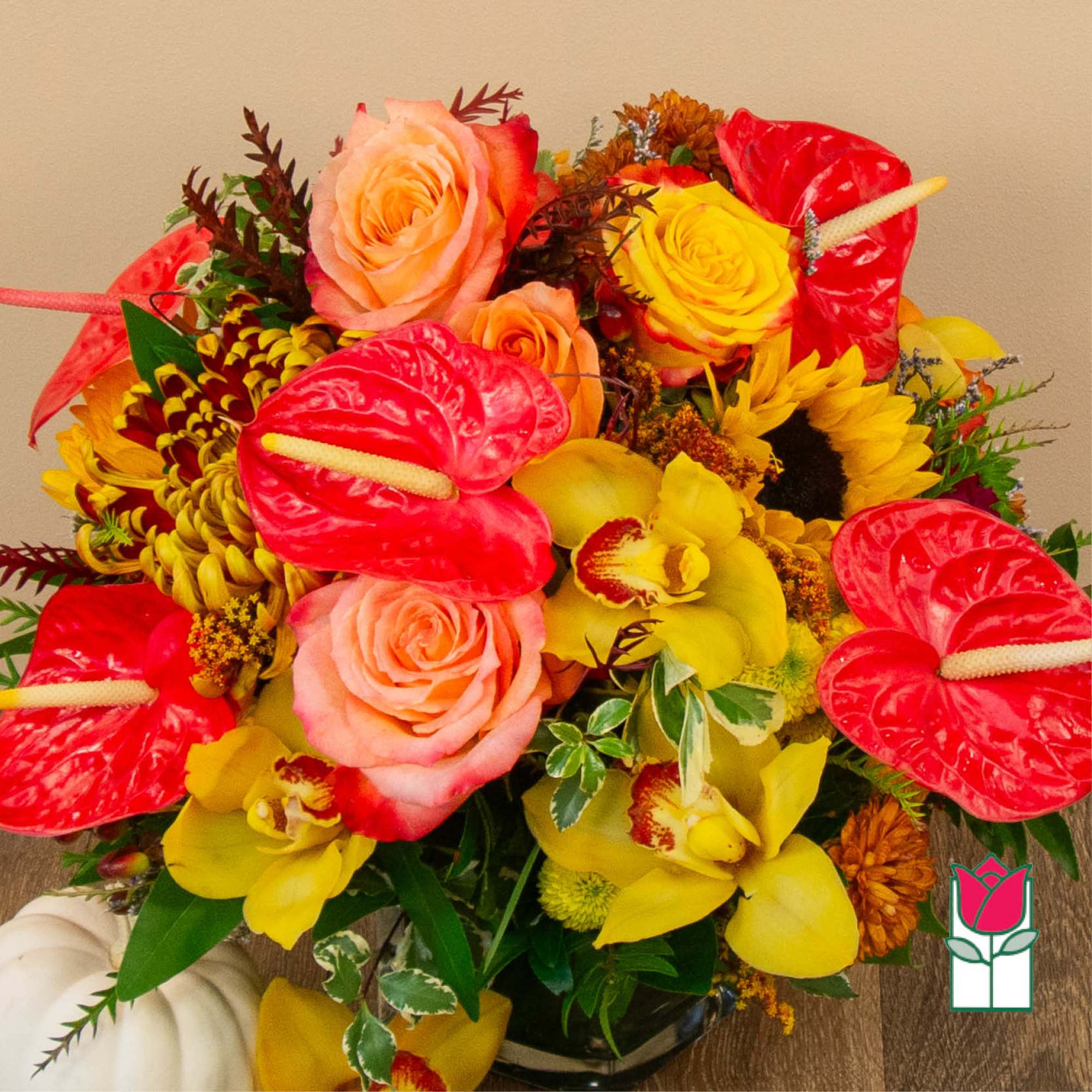 Bright mixed bouquet with roses, orchids, sunflowers, and red anthuriums in a vase