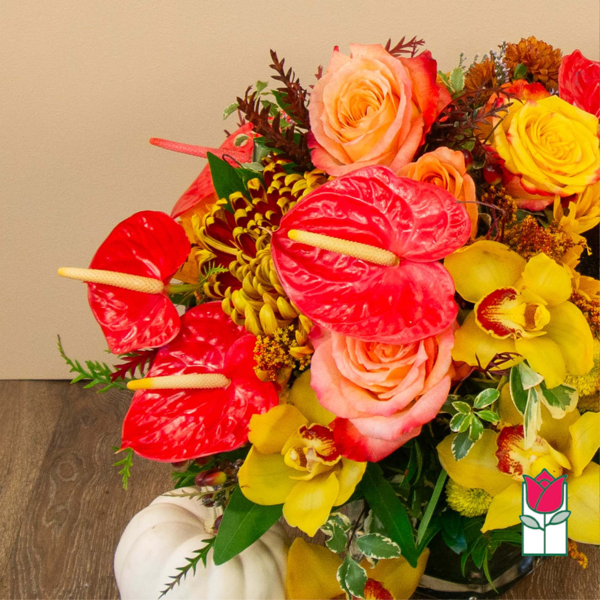Bright mixed bouquet with roses, orchids, and red anthuriums in a vase