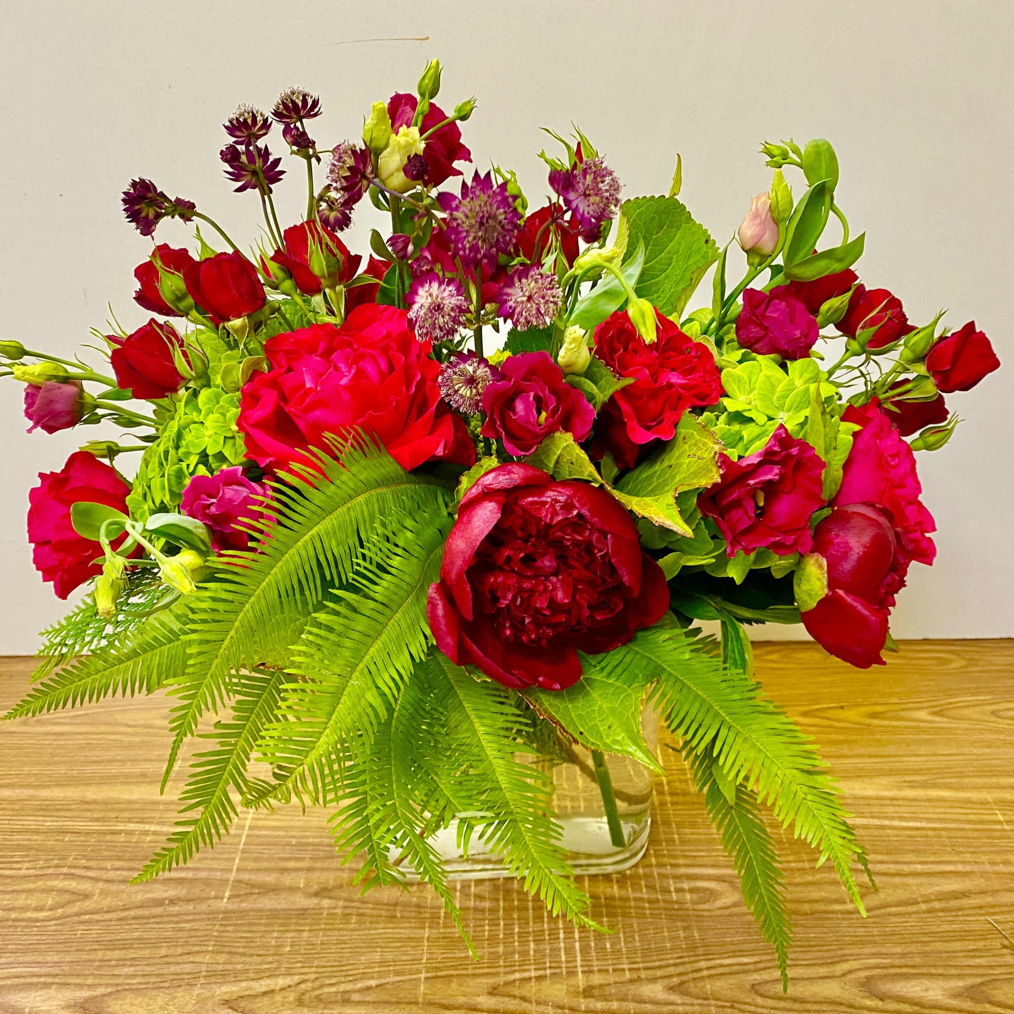 Red and pink floral arrangement in a clear glass vase