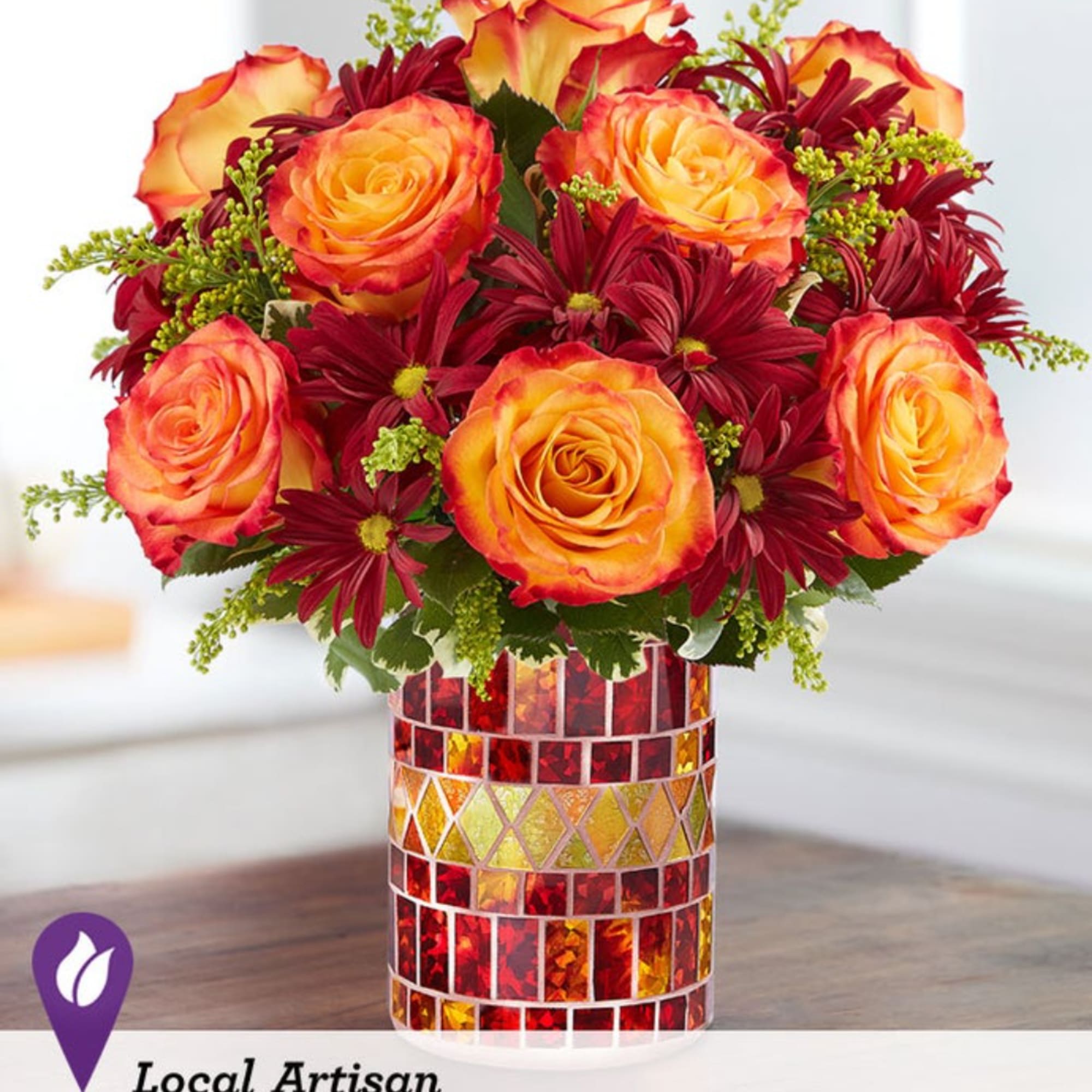 Orange roses and burgundy daisies in a mosaic glass vase