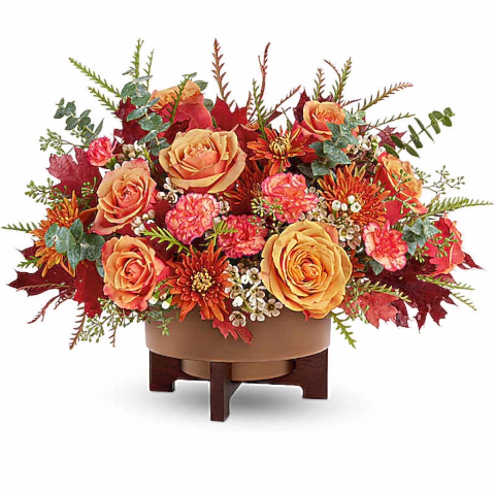 Autumn floral arrangement with orange roses and red blooms in a low container
