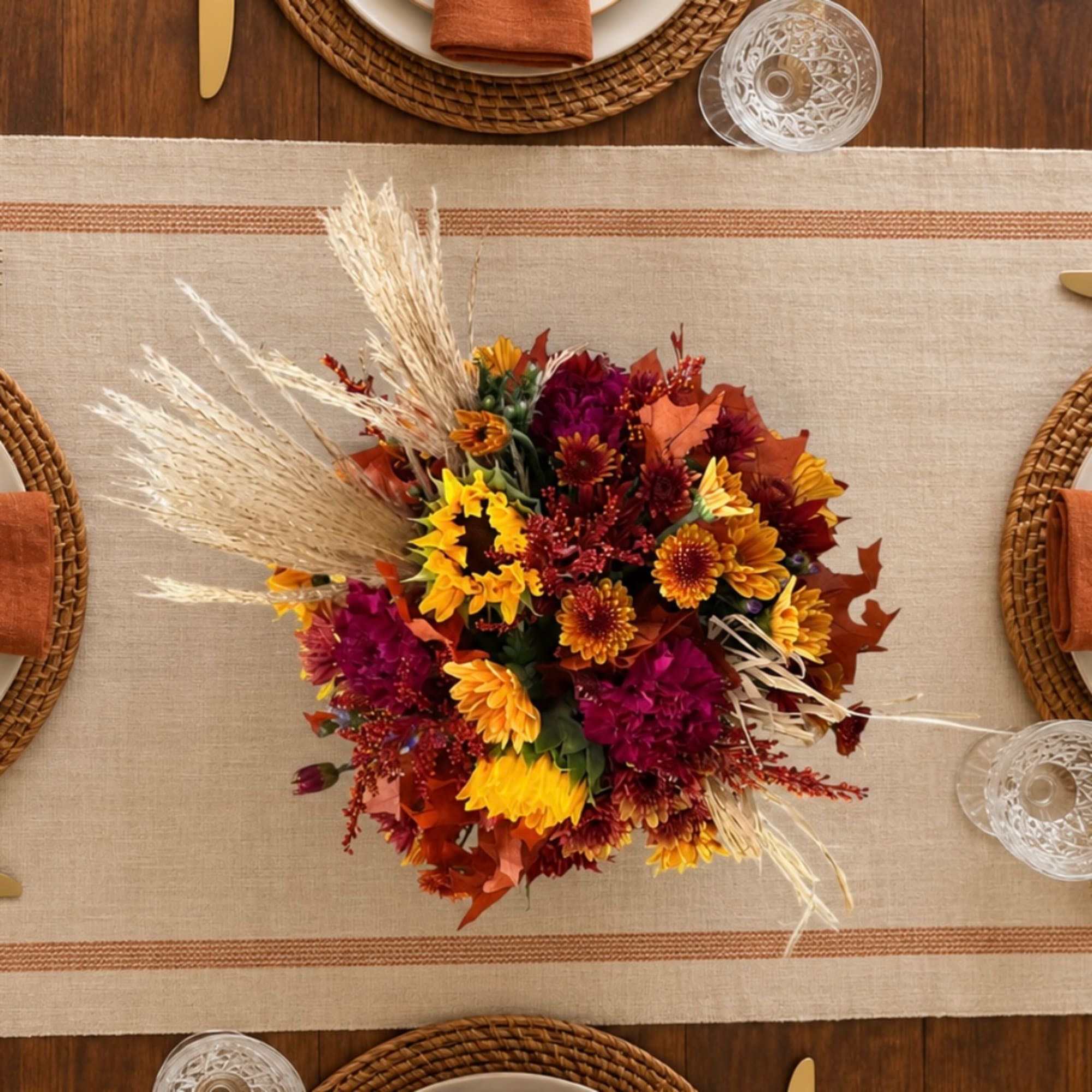 Autumn floral centerpiece with yellow and burgundy blooms on a table runner