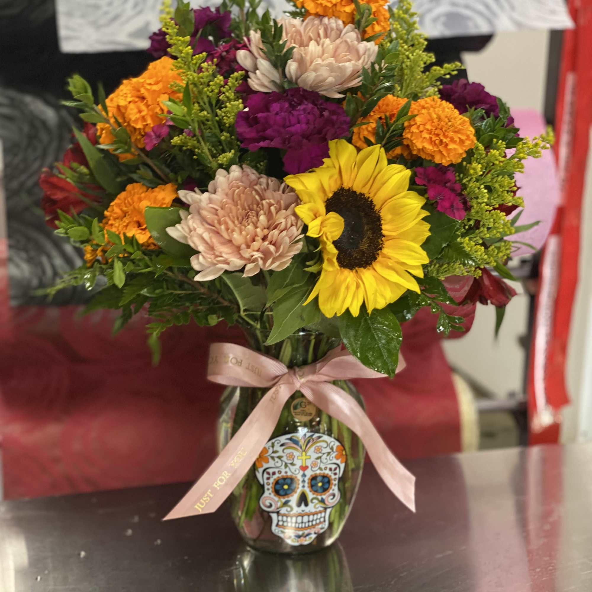Mixed bouquet in a glass vase with a sunflower and bright mums