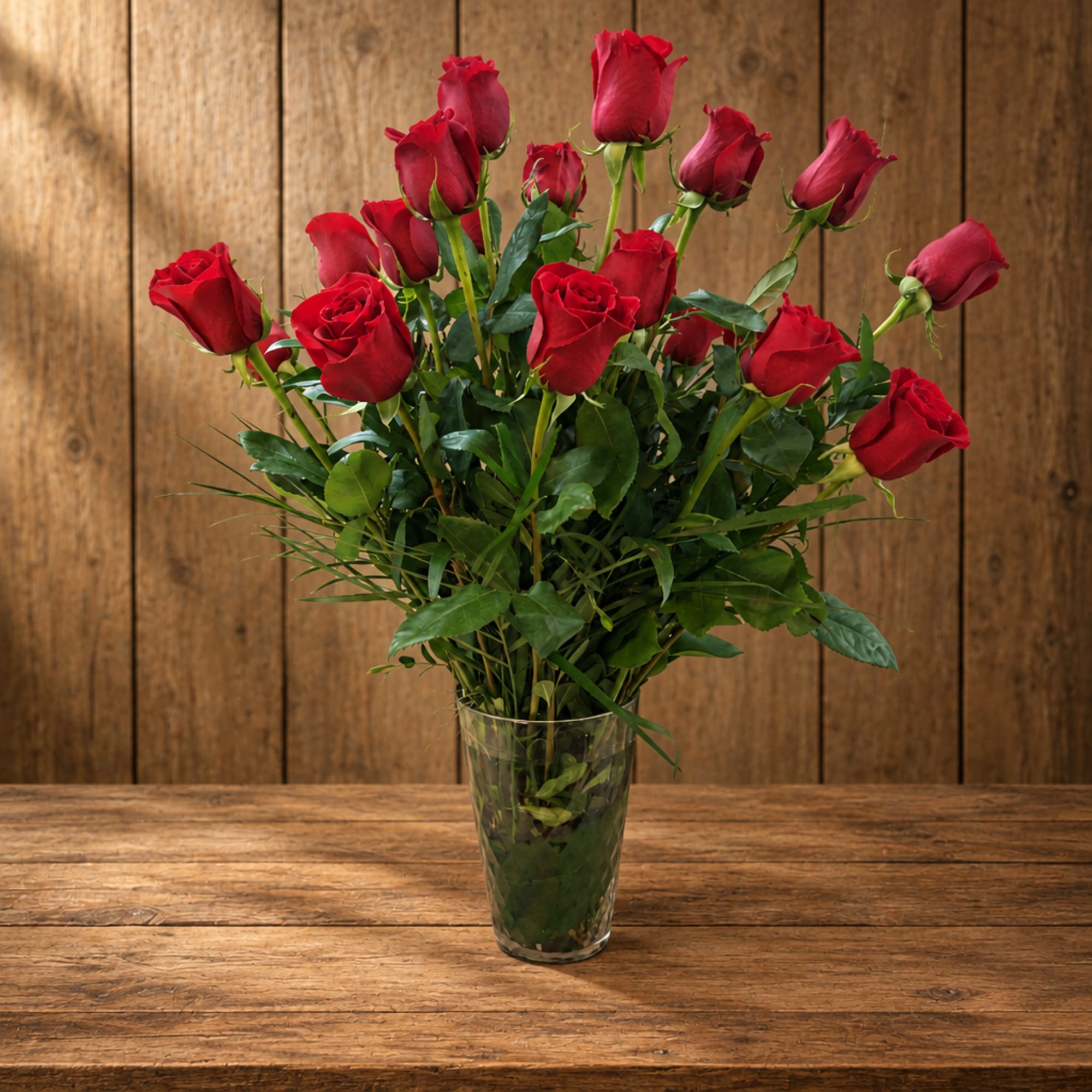Red roses arranged in a clear glass vase
