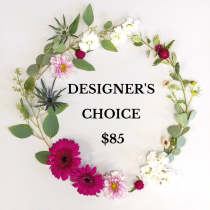 Flat lay wreath of mixed pink, white, and green flowers encircling text reading Designer's Choice $85