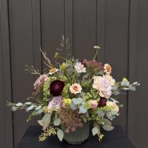 Mixed bouquet in a ribbed vase with burgundy, blush, and cream flowers