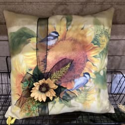 Decorative sunflower pillow with a small floral accent and ribbon