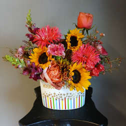 Mixed bouquet with sunflowers, roses, and bright pink blooms in a white box
