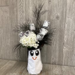 White roses and hydrangeas in a smiling ghost-shaped vase