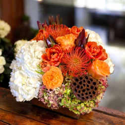Compact bouquet of orange and white flowers with a lotus seed pod