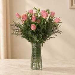 Pink roses arranged in a clear glass vase