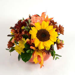 Autumn bouquet with a sunflower and chrysanthemums in a peach vase