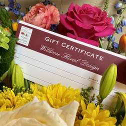 Gift certificate surrounded by colorful flowers including roses, tulips, and lilies