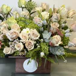 Cream roses and green hydrangeas in a wooden box arrangement