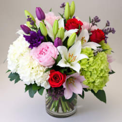 Bouquet of lilies, roses, hydrangeas, and peonies in a glass vase
