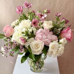 Pink and white flower arrangement in a clear glass vase