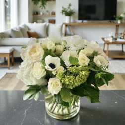 White floral bouquet in a clear glass vase on a table