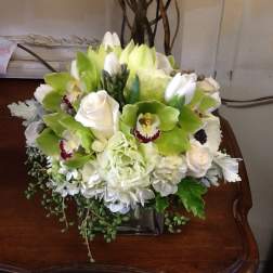White and green floral arrangement in a square vase