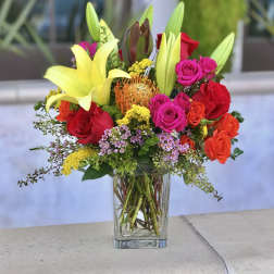 Mixed bouquet of lilies and roses in a clear glass vase